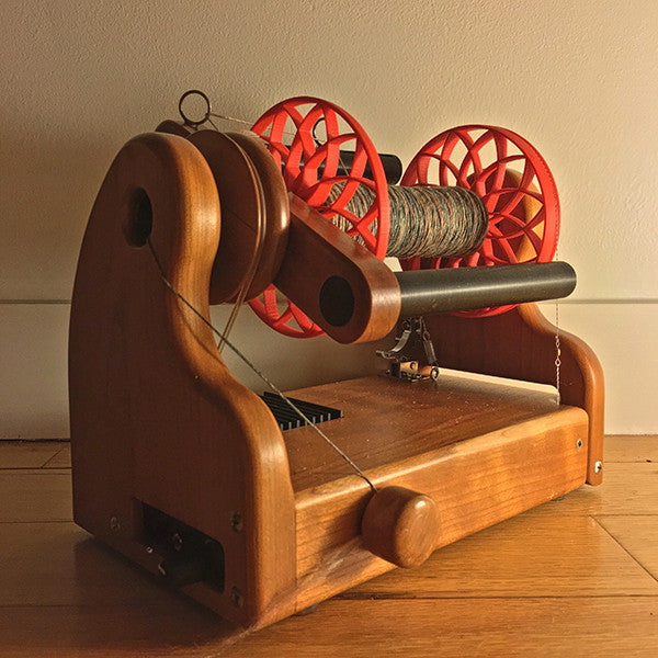 Flat-Pack Bobbin with Lotus whorls in Red, shown on wheel